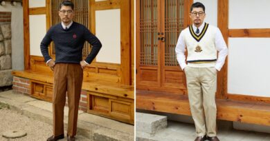 How to wear a cable knit sweater, Ivy style: a navy cable crewneck over a white button-down with brown corduroys, beside an ivory cotton cricket vest with a crest over a white oxford and tie