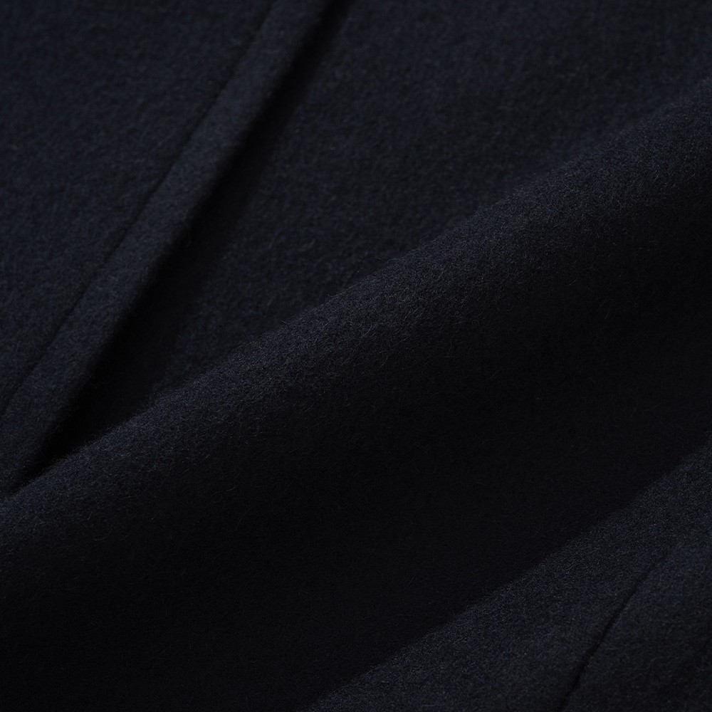 Close-up of the navy camel and wool cloth of a polo coat