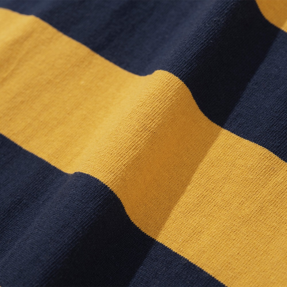 Close-up of mustard yellow and navy horizontal stripes on heavy cotton jersey, showing the knit texture of a rugby shirt